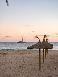 Sunset on the beach with straw umbrellas