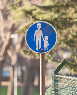 Close-up of road sign on wooden post