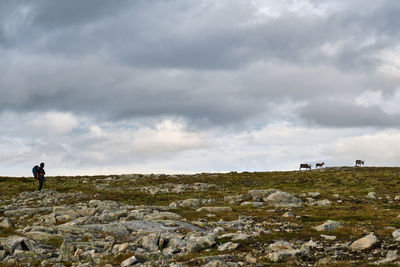 Man on rock against sky