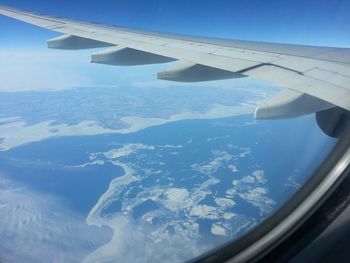 Low angle view of airplane wing over sea