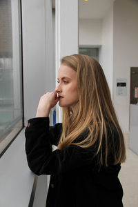 Teenage girl looking through window