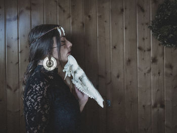 Young woman standing against wall