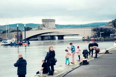 Tourists on bridge over river in city