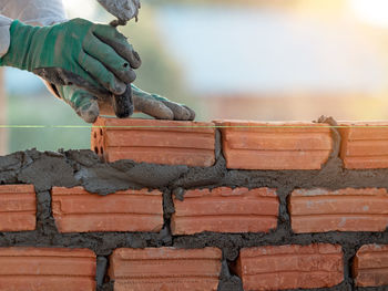 Close-up of man working on wood against wall