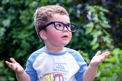 Adorable boy with over sized glasses asks  why