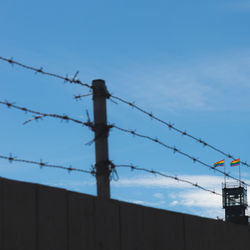 Low angle view of barbed wire against sky
