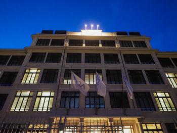 Low angle view of illuminated building against blue sky