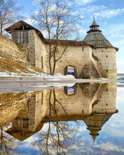 Reflection of building on lake against sky