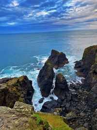 Scenic view of rocks on shore against sky