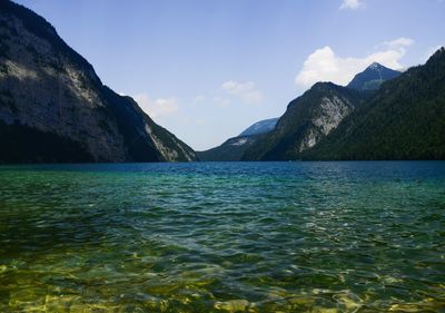 Scenic view of sea by mountains against sky