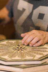 Close-up of hand holding book on table