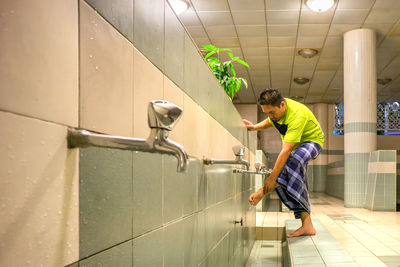 Man washing leg in bathroom