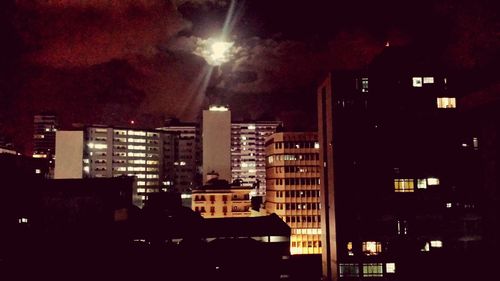 Illuminated cityscape against sky at night