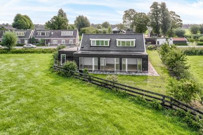 House on field by trees against sky