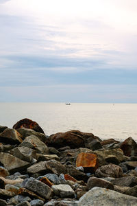 Rocks on sea shore against sky