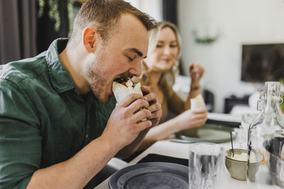 Man eating mexican burrito at home