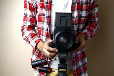 Midsection of man holding camera