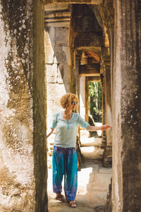 Smiling mid adult woman standing at ankor wat temple