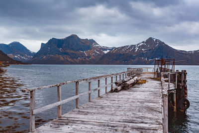 Scenic view of lake by snowcapped mountains against sky