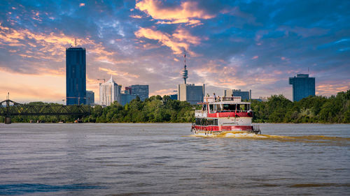 Boat in sea by buildings against sky in city
