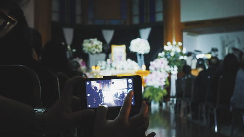 Close-up of hand holding mobile phone at home