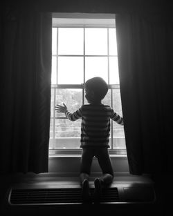 Boy kneeling in front of window