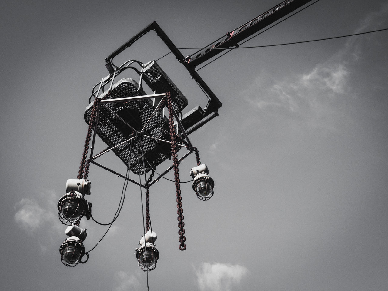 low angle view, sky, amusement park, arts culture and entertainment, amusement park ride, cloud - sky, crane - construction machinery, hanging, metal, outdoors, technology, day, no people, lighting equipment, electricity, silhouette, ferris wheel, construction site, tall - high, fun