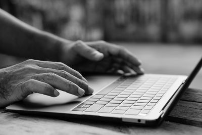 Close-up of person using laptop on table