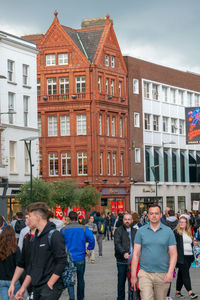 People on street against buildings in city