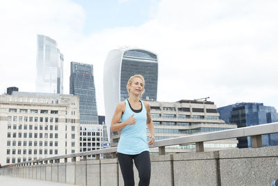 Full length of woman standing against buildings in city