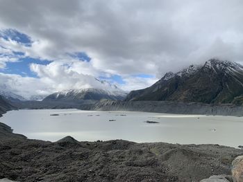 Scenic view of lake by snowcapped mountains against sky