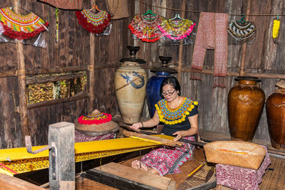 Portrait of woman sitting on display at market stall