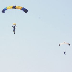 Low angle view of people paragliding