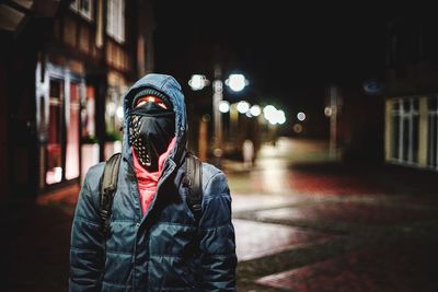 Portrait of man on illuminated street at night