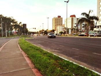 Cars on road in city against sky