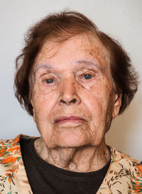 Portrait of senior woman against wall