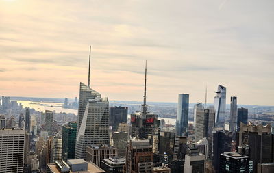 Buildings in city against cloudy sky