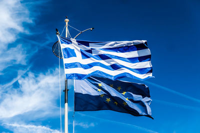 Low angle view of flag against blue sky