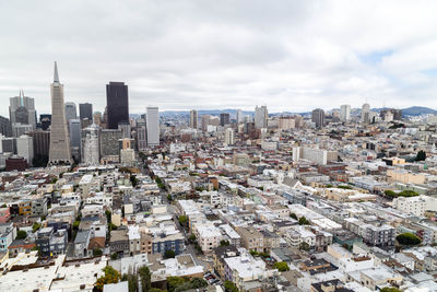 Aerial view of buildings in city against sky