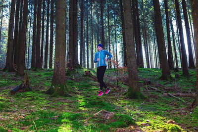 Rear view of woman walking in forest