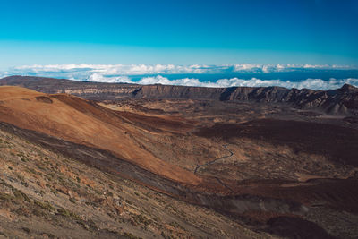 Scenic view of dramatic landscape against blue sky