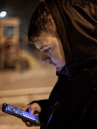 Side view of young woman using mobile phone