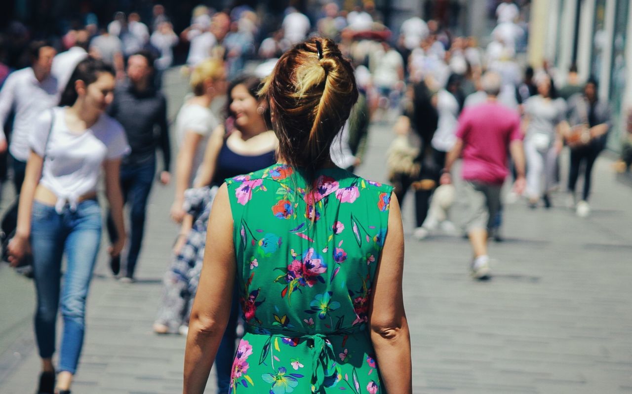 rear view, real people, lifestyles, women, focus on foreground, incidental people, casual clothing, group of people, city, leisure activity, day, hairstyle, adult, crowd, people, street, walking, outdoors, floral pattern, festival