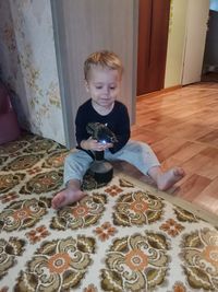 Full length of boy sitting on floor at home