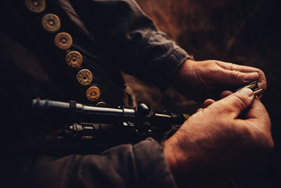 Midsection of hunter with sniper on field