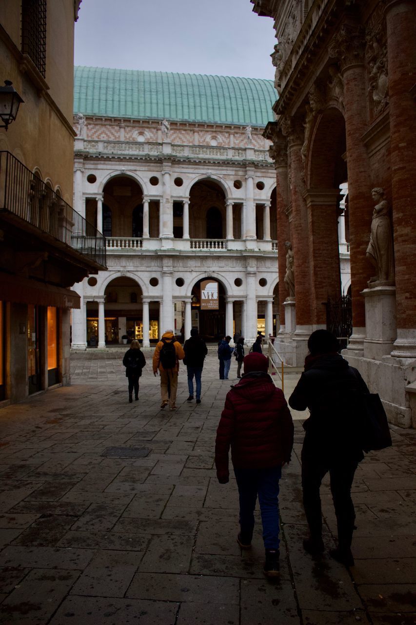 PEOPLE WALKING IN FRONT OF HISTORIC BUILDING