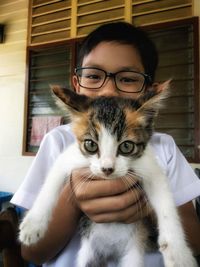 Portrait of boy holding kitten