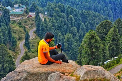 People sitting on rock against mountain