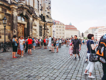 People on street against buildings in city