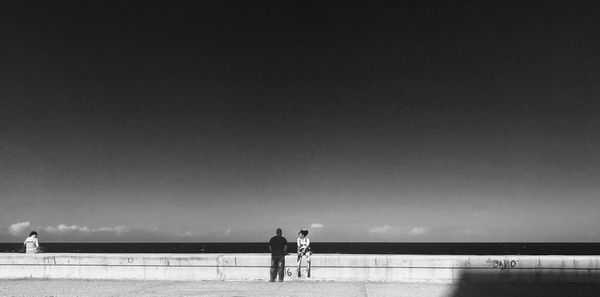 People at beach against sky